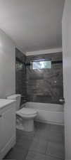 Full bathroom with tiled shower / bath combo, vanity, toilet, and tile patterned floors