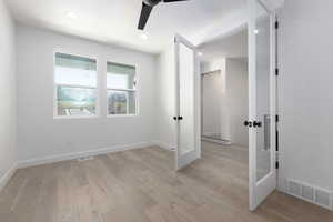 Unfurnished room featuring french doors, light hardwood / wood-style flooring, and ceiling fan