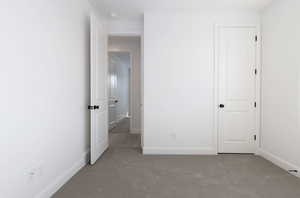 Unfurnished bedroom with light colored carpet