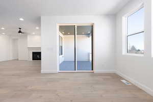 Unfurnished room featuring ceiling fan, light hardwood / wood-style floors, and a healthy amount of sunlight