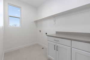 Clothes washing area with washer hookup, cabinets, and hookup for an electric dryer