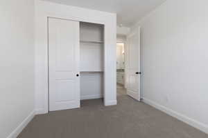 Unfurnished bedroom with carpet and a closet