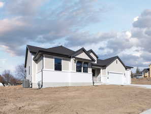 View of front of property with a garage and central AC