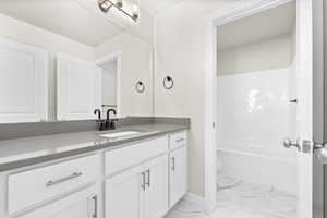 Full bathroom with vanity, toilet, and  shower combination