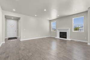 Unfurnished living room featuring a textured ceiling, plenty of natural light, and light hardwood / wood-style flooring