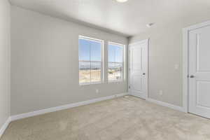 Carpeted empty room with a textured ceiling