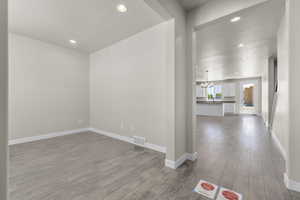 Hall with a textured ceiling, hardwood / wood-style floors, and an inviting chandelier