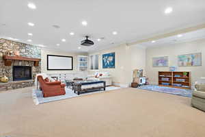 Carpeted living room featuring a fireplace and ornamental molding