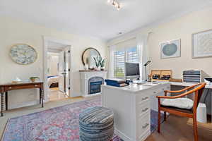 Office space with crown molding and light colored carpet