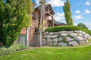 View of side of property featuring a yard and a balcony