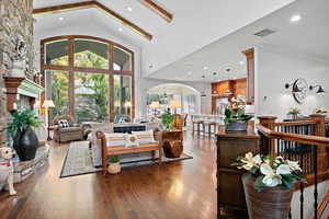 Living room featuring high vaulted ceiling, dark hardwood / wood-style flooring, and beamed ceiling