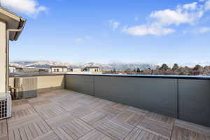 View of patio with a mountain view, central AC, and a balcony