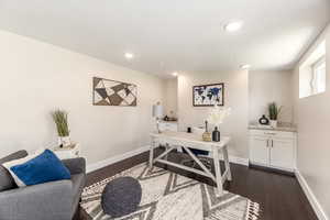 Office area with dark hardwood / wood-style flooring