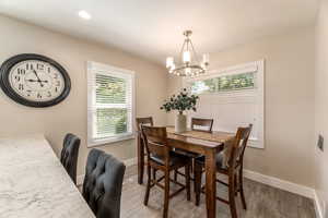 Dining space featuring an inviting chandelier and dark hardwood / wood-style flooring