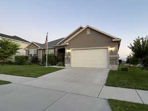 View of front of property featuring a yard and a garage