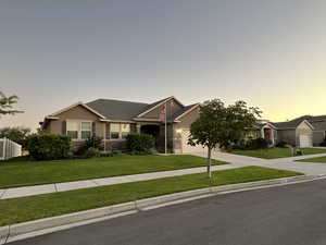 View of front of property featuring a lawn and a garage