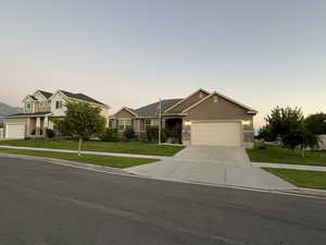 View of front facade with a garage and a yard