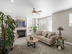 Carpeted living room with built in features, ceiling fan