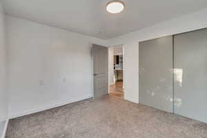 Unfurnished bedroom with a closet and carpet floors