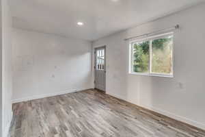 Empty room with hardwood / wood-style flooring