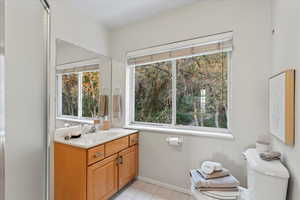 Bathroom featuring tile patterned flooring, toilet, and vanity