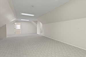 Bonus room featuring lofted ceiling and carpet floors