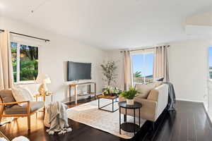 Living room featuring a healthy amount of sunlight and dark hardwood / wood-style floors