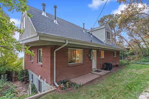 Back of property with a lawn and central air condition unit