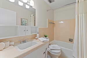 Full bathroom featuring vanity, toilet, and shower / bath combo with shower curtain