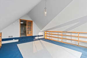 Additional living space featuring lofted ceiling and carpet floors