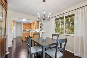 Dining room featuring dark wood-type flooring and a chandelier