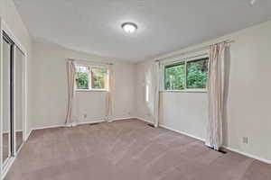 Spare room featuring a textured ceiling and carpet floors