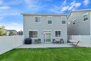 Back of property with a yard and a patio