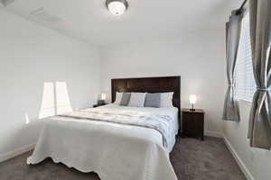 Bedroom featuring dark carpet