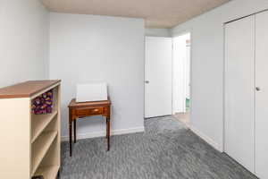 Bedroom with a textured ceiling and carpet