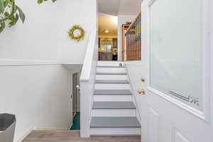 Stairs featuring hardwood / wood-style flooring