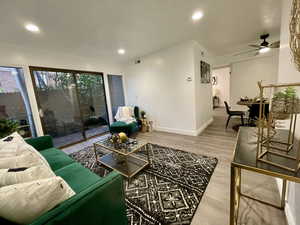 Living room featuring ceiling fan and hardwood / wood-style floors