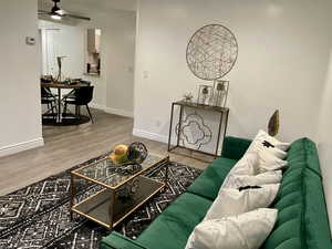 Living room with ceiling fan and wood-type flooring