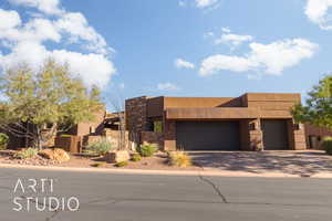 Pueblo-style house featuring a garage