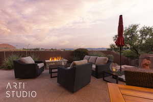 Patio terrace at dusk with an outdoor living space with a fire pit