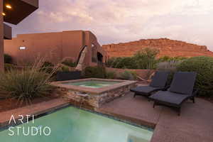 Pool at dusk featuring a patio, a mountain view, and an in ground hot tub