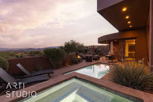 Pool at dusk featuring a patio area