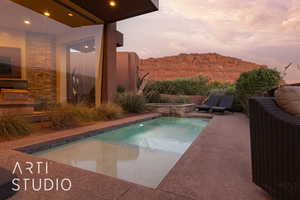 Pool at dusk with a mountain view and a patio area