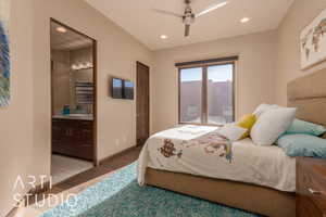 Bedroom with ceiling fan, hardwood / wood-style flooring, connected bathroom, and sink