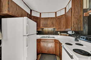 Kitchen featuring white appliances, sink, and a textured ceiling