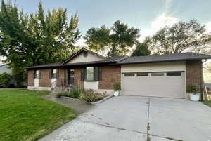 View of front of property with a garage and a front lawn