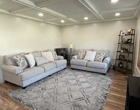 Living room with coffered ceiling, beamed ceiling, and laminate floors