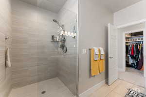 Primary Bathroom featuring tiled shower and tile patterned flooring