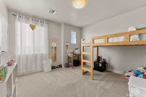 Bedroom with a textured ceiling and light colored carpet