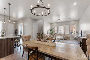 Dining area featuring a textured ceiling, hardwood / wood-style floors, ceiling fan with notable chandelier, and sink